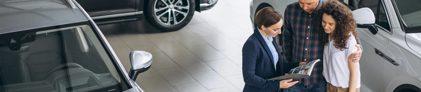 araba kiralamaya gelen aileyle ilgilenen rent-a-car elemanı